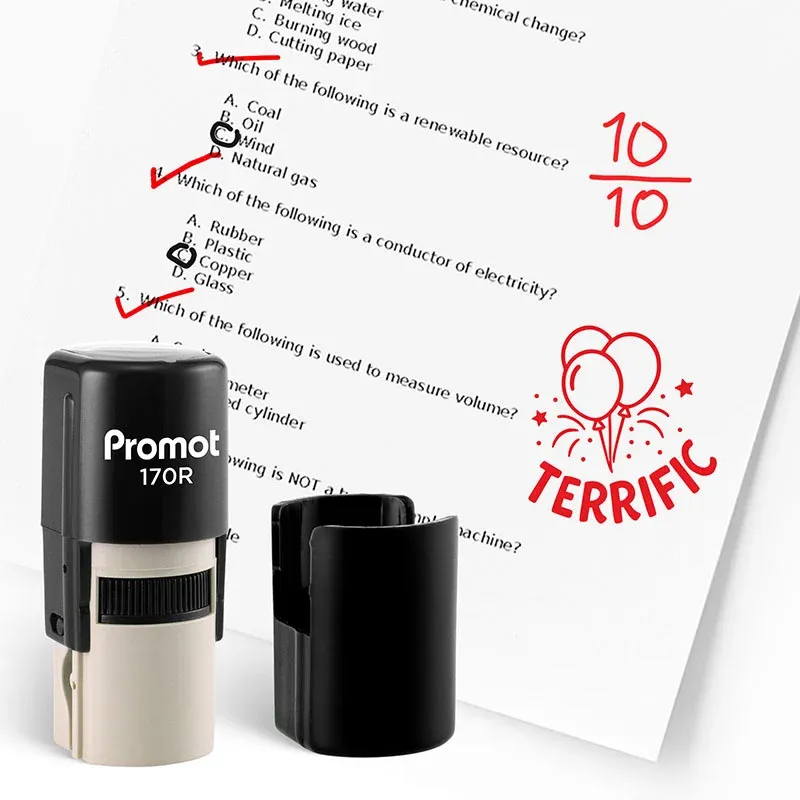 Black self inking teacher stamp and removable cap displayed beside a graded science worksheet marked with red check marks and a “10/10” score. A red balloon stamp on the page says “TERRIFIC,” showing how the classroom stamp can be used to reward student a