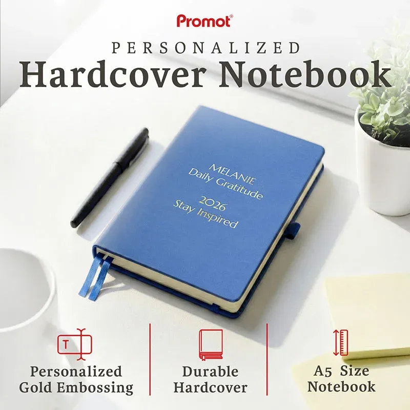 Blue personalized leather journal with custom gold embossed text, displayed on a desk to highlight its durable hardcover and A5 size.