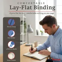 Man writing in an open blue personalized leather journal on a desk, highlighting its lay-flat design and ribbon bookmarks.