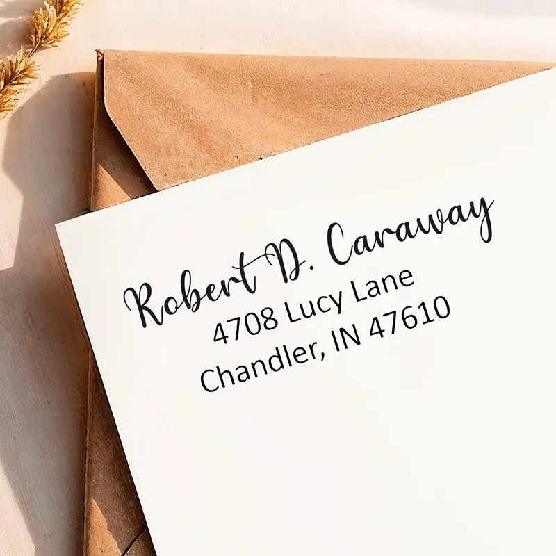 A bold return address from a large self-inking address stamp printed clearly on a white envelope.