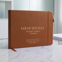 Personalized notary journal in brown vegan leather with custom gold foil name, county, and state on the cover